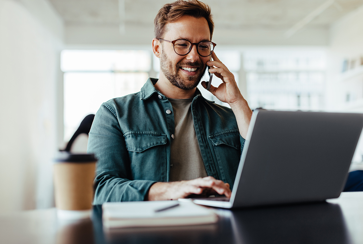 Software designer speaking to his client on the phone in an office